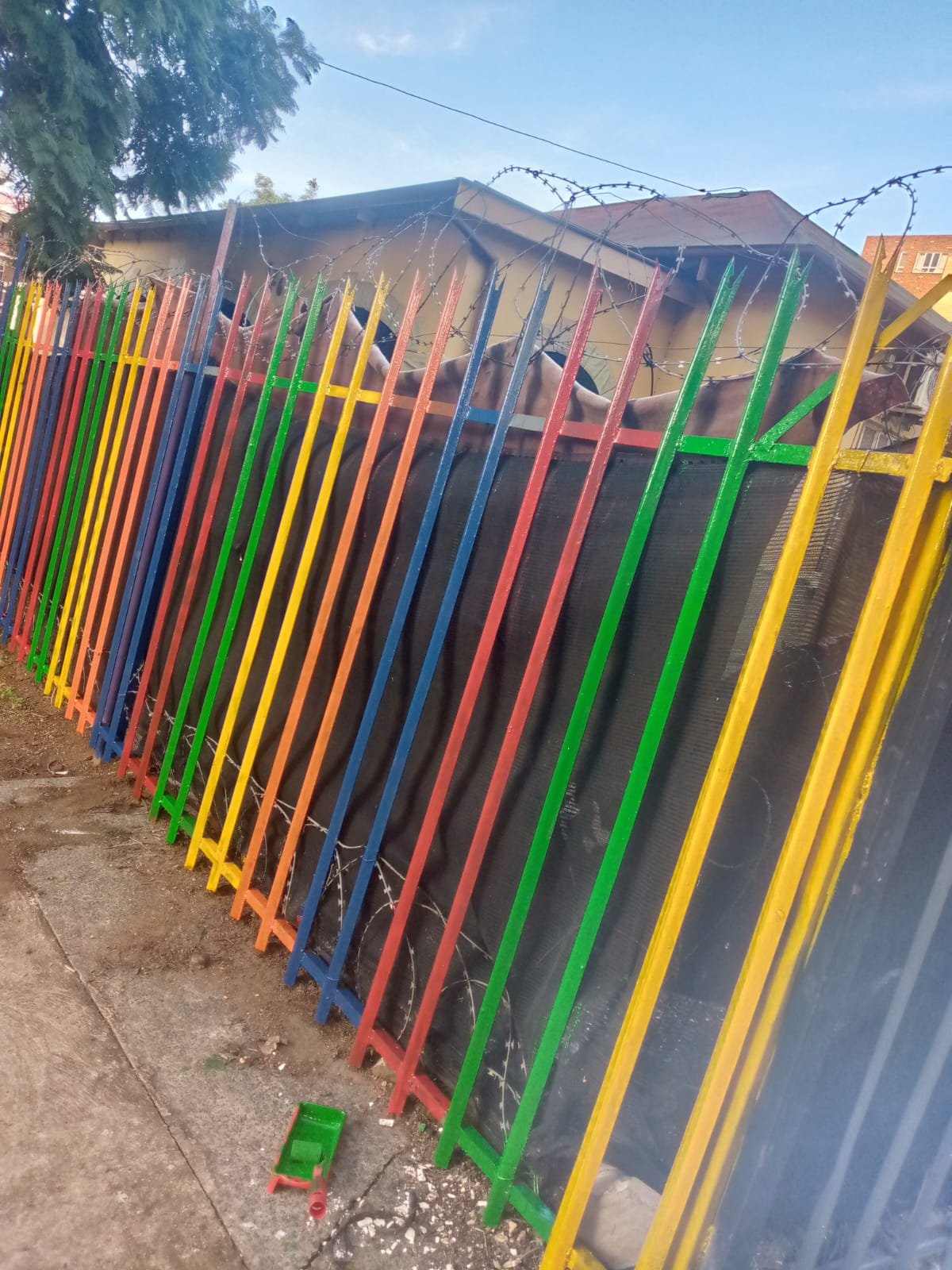 Freshly painted multi-coloured palisade fence at a Pretoria crèche